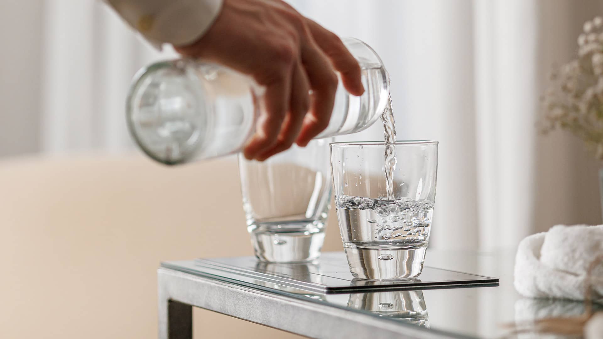 Persona sirviendo agua en un vaso
